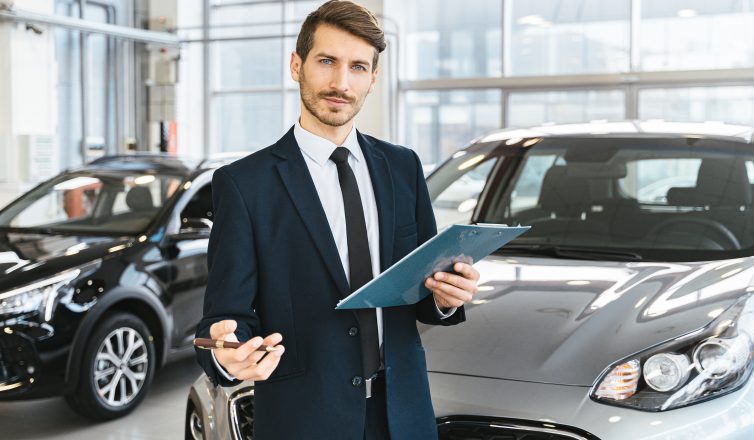 man holding a chart in front of a car
