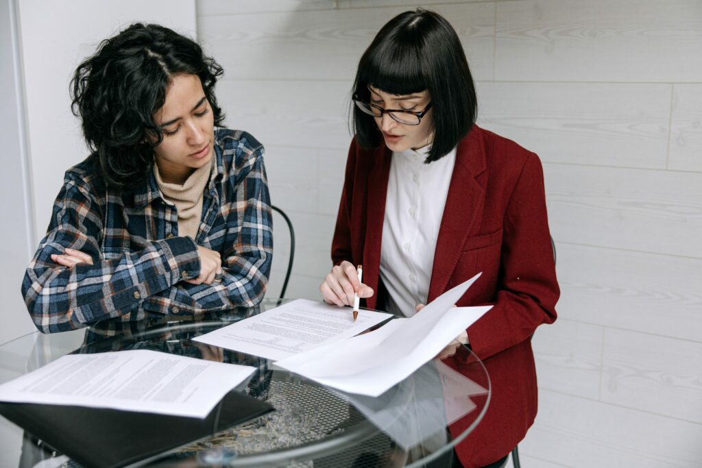 two women discussing paperwork