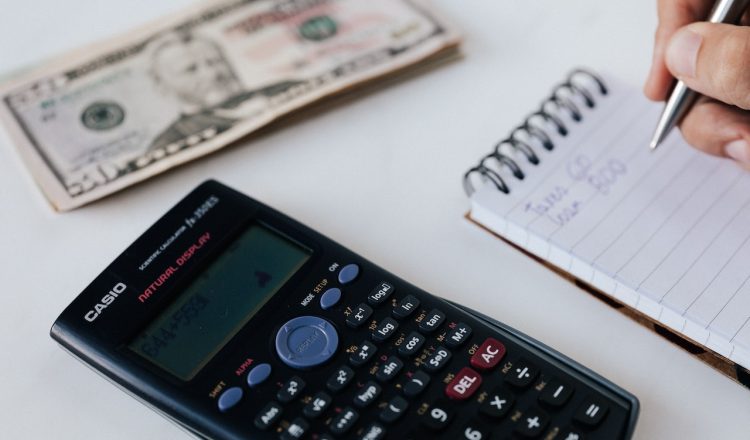 bills, calculator, and notepad on a table
