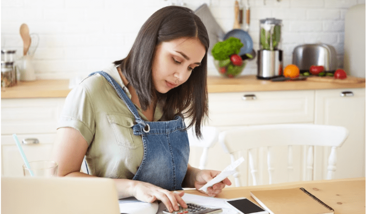 Woman computing debts and bills on the calculator