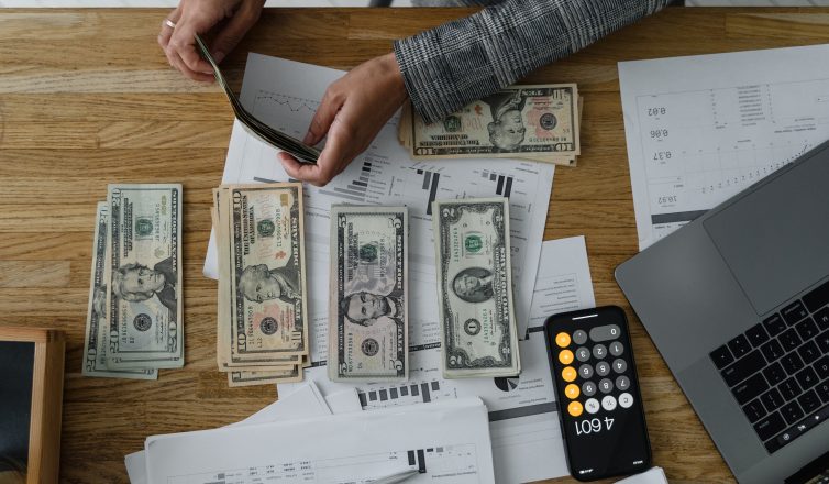 Person counting dollar bills on a desk